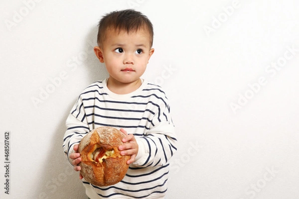 Fototapeta パンを食べているかわいい男の子。