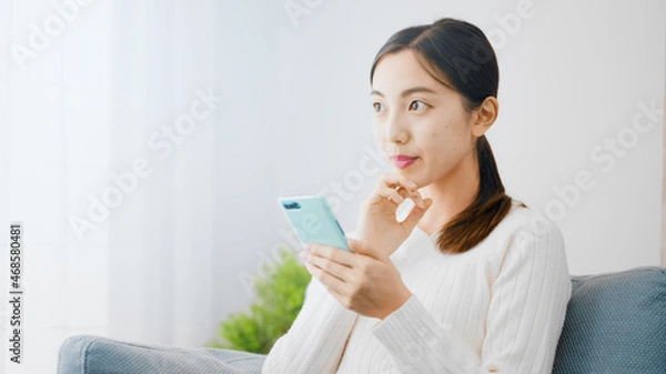 Fototapeta スマートフォンを使う若い女性