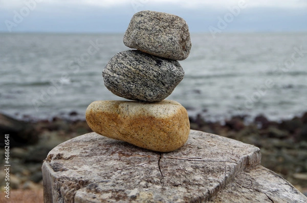 Fototapeta Three stacked stones with sea shore background. Concept of stability.
