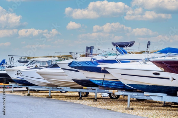 Fototapeta Boat on stand on the shore, close up on the part of the yacht, luxury ship, maintenance and parking place boat