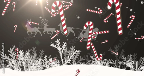 Fototapeta Image of merry christmas text over candy cane falling and winter landscape