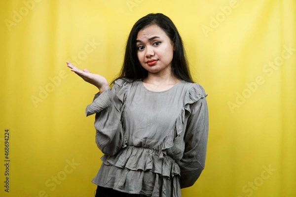 Fototapeta Beautiful young woman with hands presenting something on empty space, isolated
