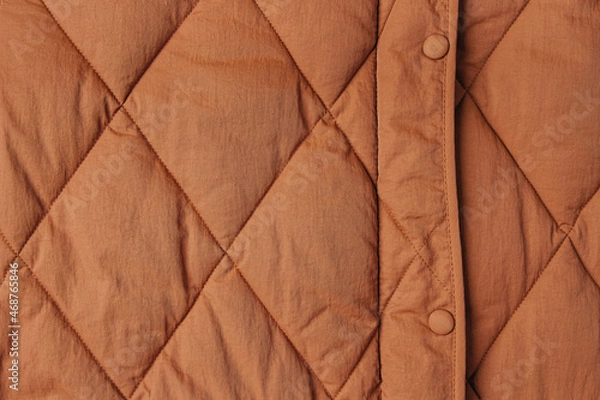 Fototapeta Close-up on brown puffer jacket texture. Quilted fabric background