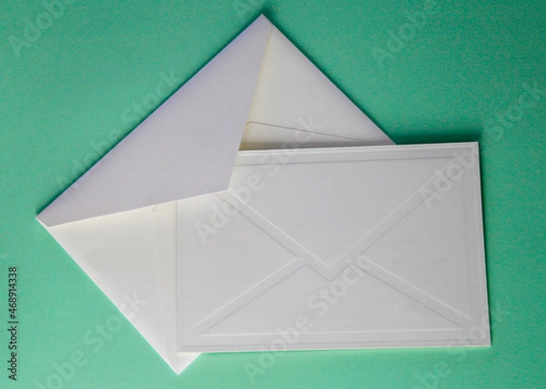Fototapeta white paper envelope with blank invitation and on green background