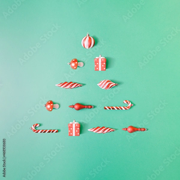 Obraz Minimal Christmas flat lay with colorful decorations on pastel green background. Creative xmas tree design.