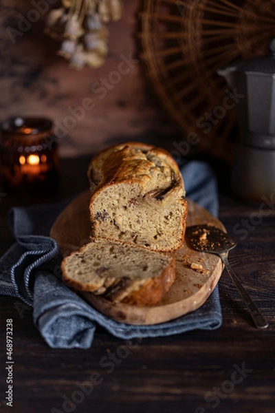 Fototapeta Fresh home made banana bread or butter sponge cake on rustic dark wooden table, organic country still life dessert image. Close up view with copy space. 