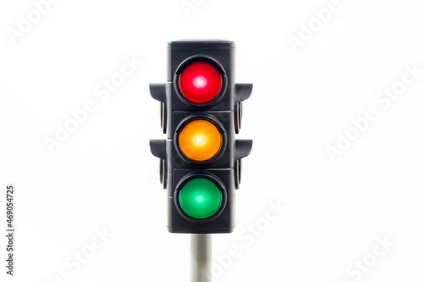Obraz Isolated traffic light showing an illuminated red, amber and, green light.  Concept image illustrating possible confusion over decision making.