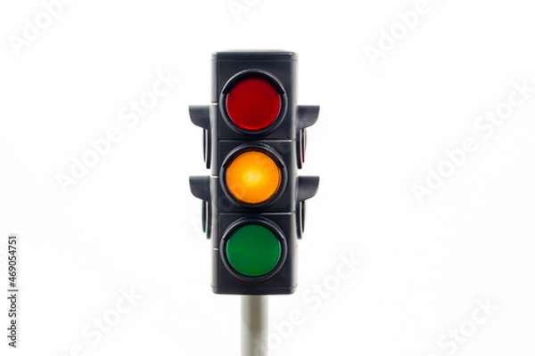 Obraz Isolated traffic light showing an illuminated amber light.  Concept image illustrating control of the COVID pandemic and the safe movement between levels.

