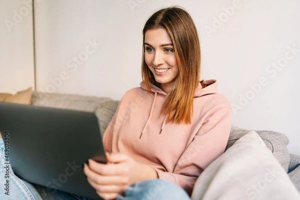 Obraz Happy interested young woman reading on a laptop computer