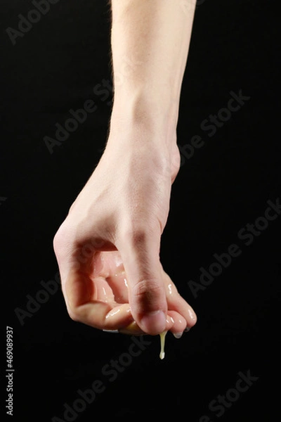 Obraz liquid flows from the hand on a black background