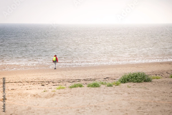 Fototapeta Lone walker in hazy weather on the beach of Föhr