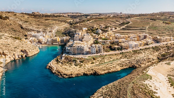Fototapeta Aerial view of Xlendi, a picturesque village in Gozo island, Malta, surrounded by steep cliffs and valleys.Xlendi Bay is popular swimming,sunbathing and diving spot with small sandy beach.Holiday