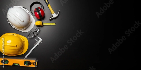 Fototapeta Work safety. Construction site protective equipment on wooden background, flat lay, copy space, top view