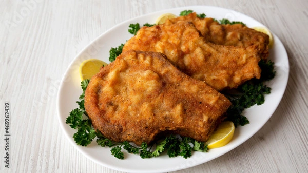 Fototapeta Homemade Fried Pork Chops on a White Plate, side view.