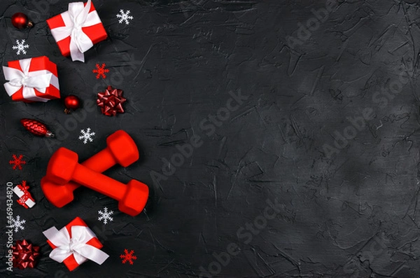 Obraz Red dumbbells with winter decorations on black background.