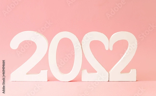Obraz New Year white numbers 2022 with heart shape against pastel pink background. Christmas and winter holidays layout.