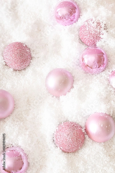 Fototapeta Christmas sparkle pink baubles in white snow pattern. Winter holidays and New Year aesthetic layout. Christmas ornaments composition.