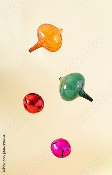 Fototapeta Christmas vintage ornaments in orange, green, red and pink colour behind pastel beige champagne background. Winter holidays and New Year ornaments layout. Retro 80s or 90s aesthetic.