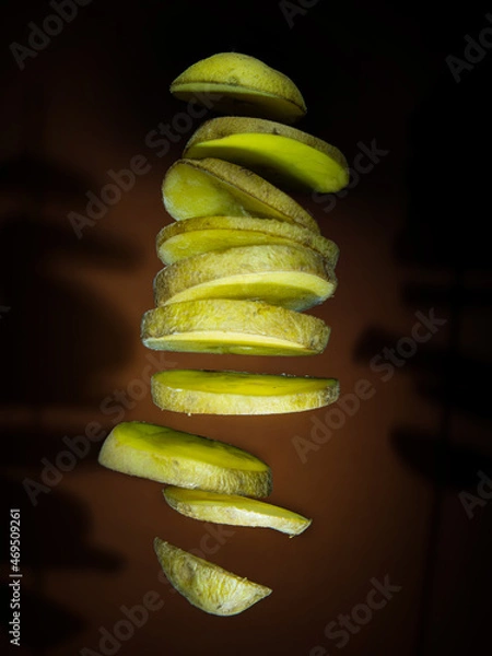 Obraz Potato slices floating on dark background