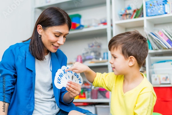Obraz A cute boy with a speech therapist is taught to pronounce the letters, words and sounds.