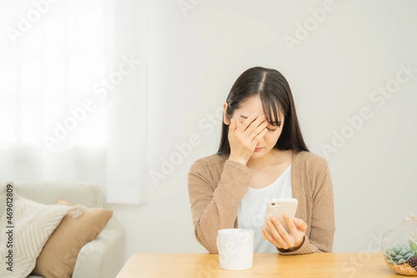 Fototapeta スマホを見てショックを受ける女性
