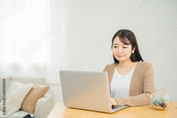 Fototapeta 家でノートパソコンを使う女性（笑顔）

