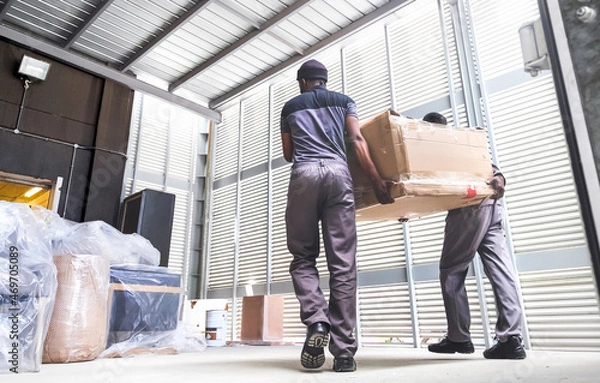 Obraz Men delivering boxes from a truck. Furniture delivery.