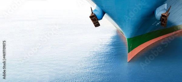 Obraz Front view of large blue merchant cargo ship in the middle of the ocean. Performing cargo export and import operations with horizon line and beautiful sky.