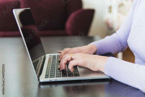 Fototapeta person hands typing on laptop on desk