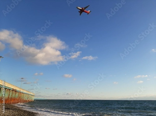 Fototapeta A small red plane in a blue sky