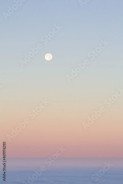 Fototapeta Moonrise over a blanket of clouds