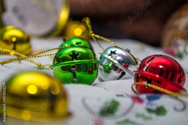 Fototapeta Multi-colored jingle bells on a light background. Selective focus. Close-up