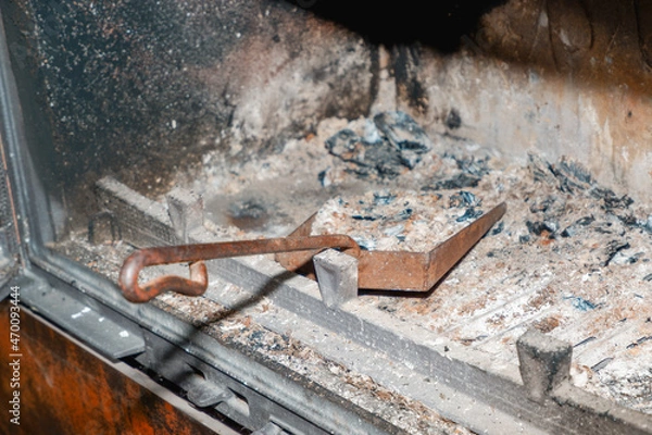 Obraz Fireplace cleaning. Fireplace cleaning tools. A shovel with ash in a burnt-out fireplace. Daily winter routine