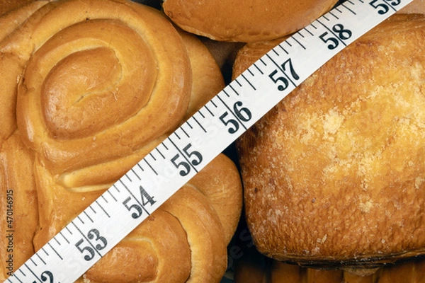 Obraz Calories counting. Inch measuring tape on sweet bakery buns. Measuring tape over pastry buns close-up. 