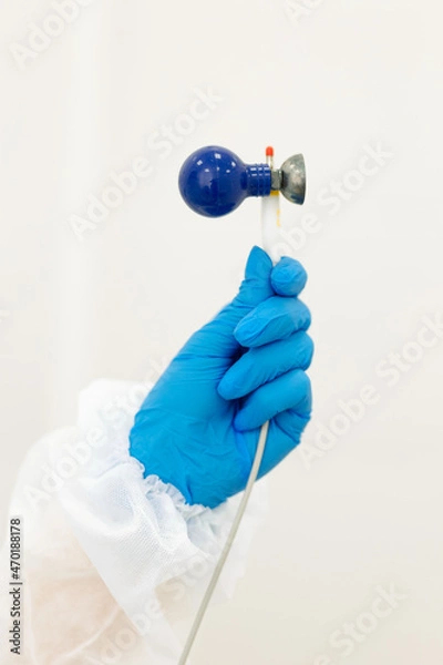 Obraz a doctor's hand in a blue rubber glove holds an electrocardiograph or ekg machine