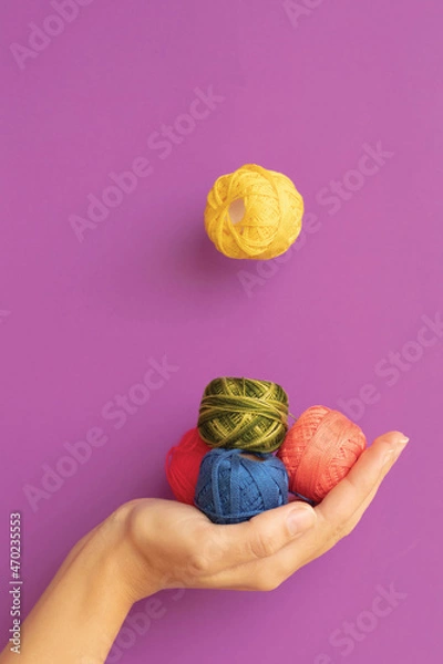 Fototapeta Embroidery threads in different strong colors on a purple background