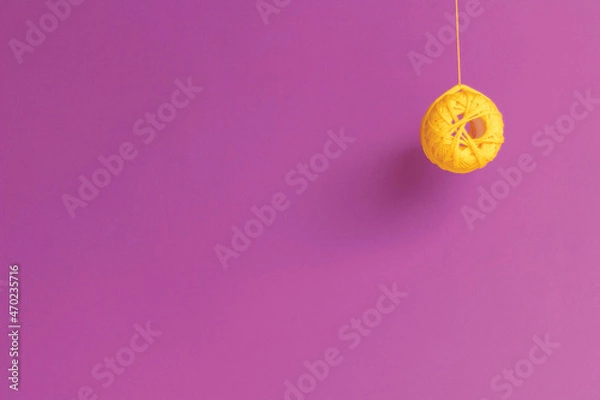 Fototapeta Embroidery curly thread in yellow on a purple background