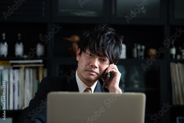 Fototapeta スマホで話すアジア人(日本人）ビジネスマン男性　コピースペースあり　アップ