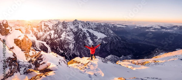 Fototapeta Hiker on a summit in a wintry mountain landscape. Climber on a summit freedom