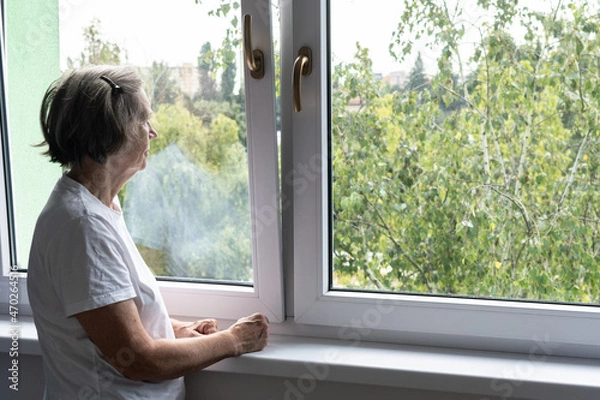 Fototapeta sad senior woman female alone home closeup depressed coronavirus isolation widower unhappy abandoned window