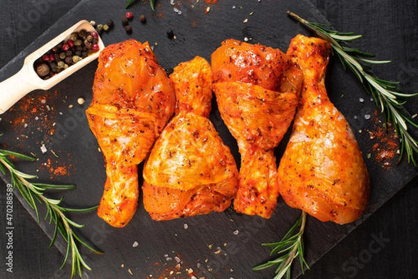 Obraz Cooking chicken drumsticks.Raw chicken legs in a marinade with rosemary and pepper.Raw chicken legs. Delicious marinated chicken legs .