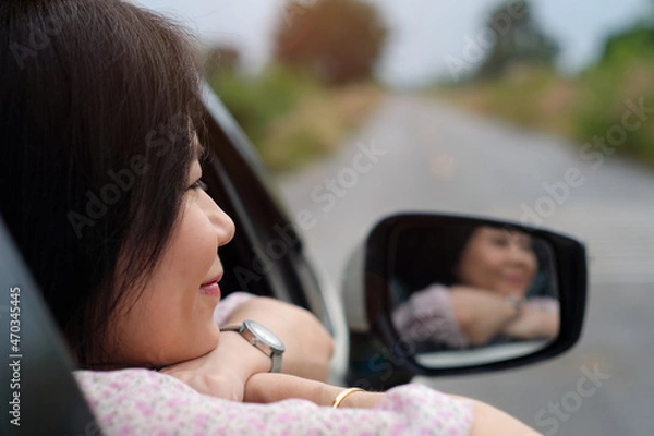 Fototapeta Beautiful woman looking a nature view while travel driving road trip.Travelling and vacation concept