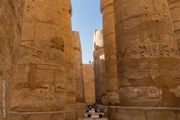Obraz Colonnade in the ancient Egyptian temple of Horus in Luxor.  Hieroglyphs are visible on the thick columns, scenes from the life of the gods are carved.  Blue sky. A sunny day.