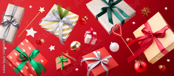Fototapeta Happy New year concept. Christmas gifts, Lollipop, decorations and toys are flying in the air on a red background. Levitation.