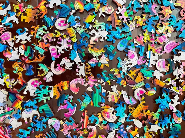 Fototapeta top view of a multitude of colored pieces of a wooden puzzle, with the shape of the pieces different from the usual