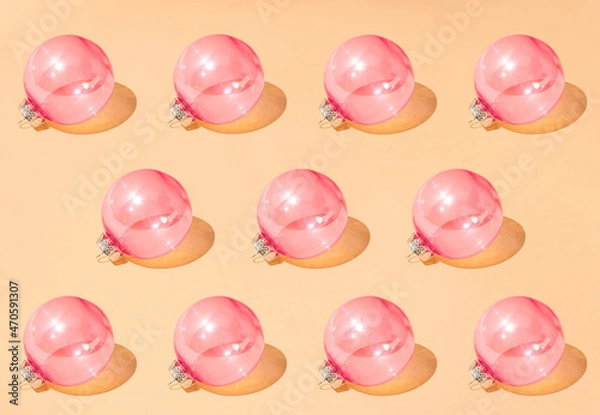 Fototapeta Christmas creative pattern made of shiny pastel pink baubles against peachy pastel background. Winter holidays and New Year celebration concept with ornaments.