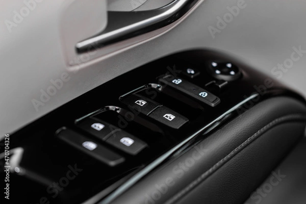 Obraz Close up view of button controlling window in modern car interior. Vehicle interior detail. Door handle with windows controls
