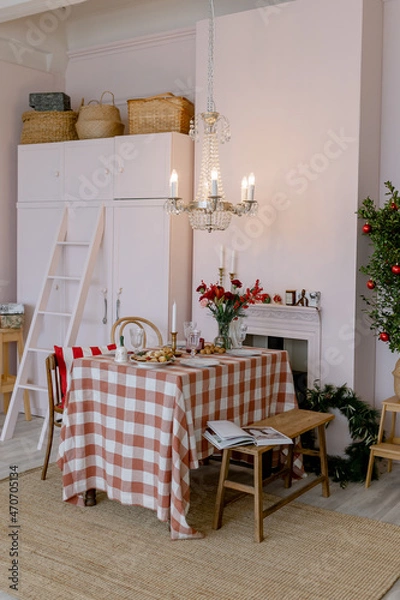 Fototapeta Christmas table in the house Pink interior Red flowers and a classic style chandelier