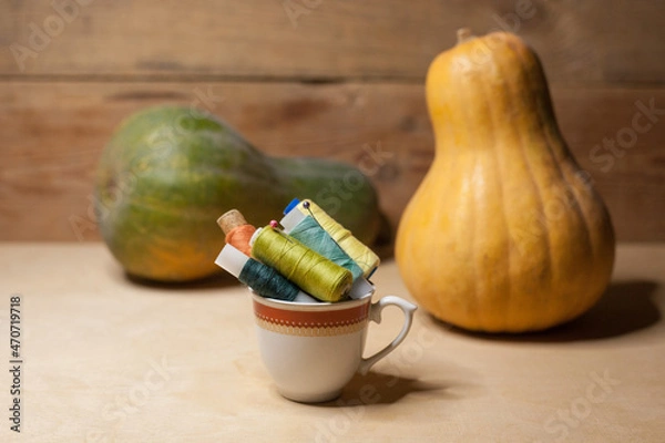 Obraz Spools of colorful thread in a coffee cup with pumkins