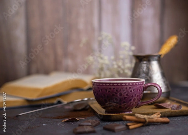 Fototapeta coffee and cinnamon on dark table with open books and wooden walls